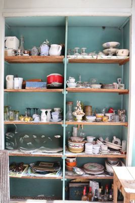 de nombreux plats et tasses sur les étagères de la cuisine