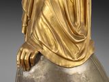 statue of a woman with a veil on her head sitting on a rock