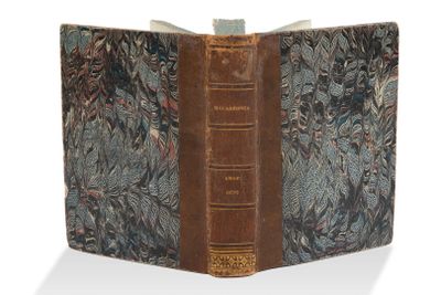 un vieux livre à la couverture brune posé sur une table
