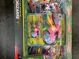 the box contains a variety of pokemon cards, including a pink and green pokemon figure