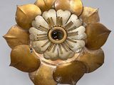 a gold flower with a black center on a white background