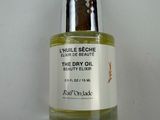 a close up of a bottle of oil on a white surface