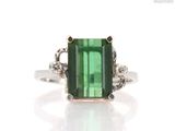 an image of a green tourmaline and diamond ring on a white background