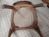 a wooden chair with a cushion on it in a room