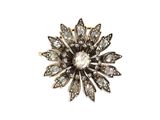 un gros plan d'une broche en forme de fleur en diamant sur fond blanc
