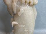 un vase blanc orné d'un dragon, posé sur une table