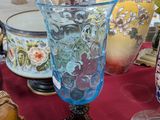 de nombreux vases posés sur une table recouverte d'une nappe rouge