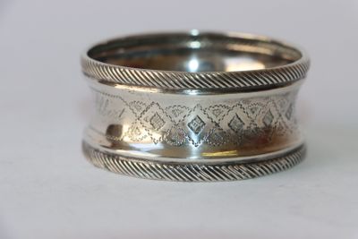 gros plan d'une bague en argent sur une surface blanche