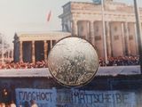 une photo d'une pièce de monnaie avec, en arrière-plan, l'image d'un bâtiment