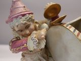 a figurine of a little girl with a hat and a drum