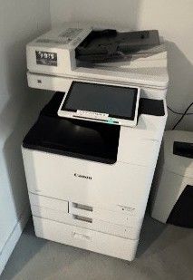 une imprimante blanche posée sur une imprimante noir et blanc
