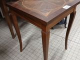 a small table with a wooden top on a tile floor