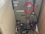 a refrigerator with a bunch of wires on the side of it