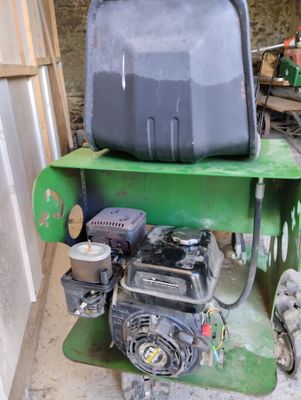a green machine with a black tank sitting on top of it