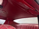 someone is sitting in the back seat of a red car