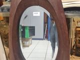 un miroir posé sur une table, à côté d'un livre