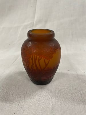 un vase en verre brun posé sur un tissu blanc