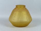 un vase jaune posé sur une surface blanche