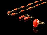 un gros plan d'un collier et de boucles d'oreilles posés sur une surface noire