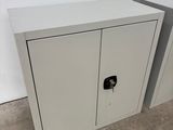 pair of white metal cabinets with a lock on the doors