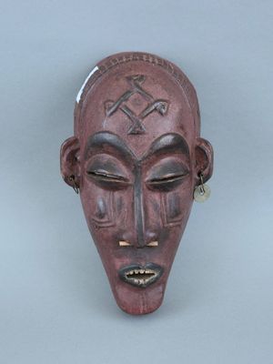 une image représentant un masque en bois orné d'une croix