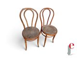 two wooden chairs with brown leather seats on a white surface