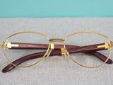 pair of glasses with gold rims on a gray surface