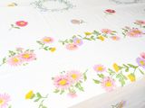 a bed with a white sheet with colorful flowers on it
