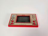an image of a red and silver game console sitting on top of a white surface
