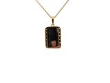 a gold necklace with a black stone pendant on a chain