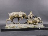 bronze sculpture of a dog chasing a deer on a rock