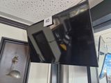 a flat screen tv hanging from the ceiling in a room