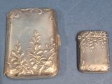two silver lighters sitting next to each other on a blue surface