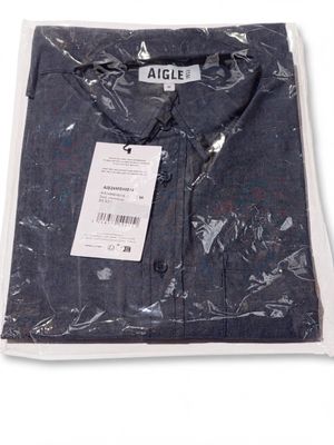 Gros plan sur une chemise dans un sac en plastique posée sur une surface blanche