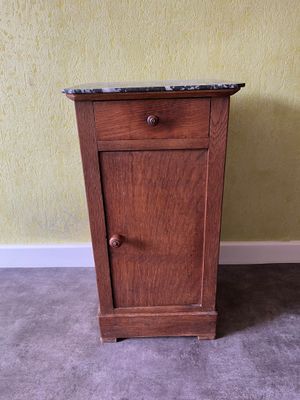 une petite armoire posée au sol, avec un plateau en marbre