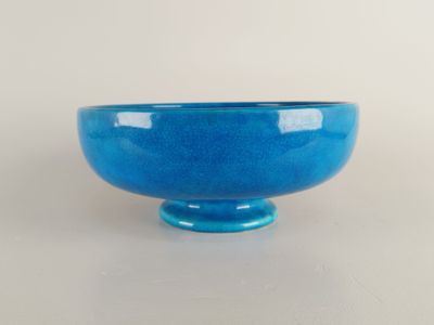 bol en verre bleu posé sur une surface blanche, sur fond blanc