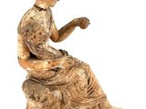 statue of a woman sitting on a rock with a book in her lap