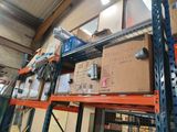 boxes are stacked on a shelf in a warehouse with a man in the background