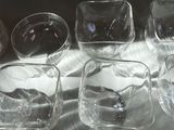 five glasses sitting on a table with a shadow