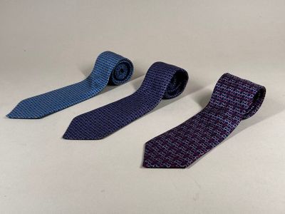 three ties are lined up on a table with a white background