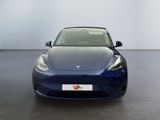 the tesla model 3 is parked in a showroom with a white wall