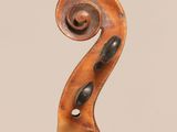 an antique violin with a scroll on the back of it