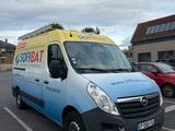 une camionnette bleue et jaune garée sur un parking