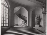 photographie en noir et blanc d'un escalier dans un immeuble où se trouve une statue