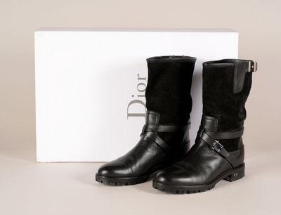 une paire de bottes noires posée sur une boîte blanche