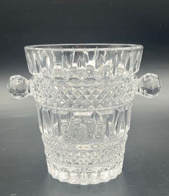 a clear glass vase with a handle on a table