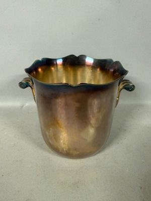 a large metal pot with handles on a white surface