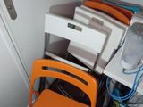 a stack of orange chairs and a computer on a desk