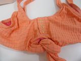 an orange bag with a knot on it sitting on a table