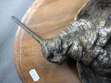 a statue of a bird with a knife in it ' s beak